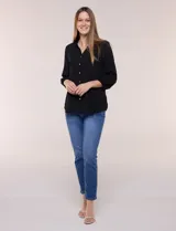 Blusa celeste de silueta suelta y textura liviana, con escote en V, cuello mao y cierre frontal de botones. Cuenta con alforzas verticales en el pecho y mangas tres cuartos con puños elastizados y detalle de galón calado.