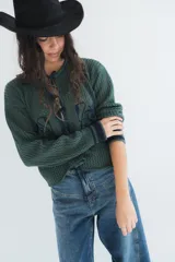Saco de punto calado en color verde oscuro con diseño estampado, mangas largas y cierre frontal con tiras para atar.