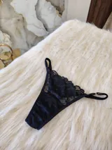 Microtanga negra de encaje con tiras regulables y corte cola less con entrepierna de algodón.