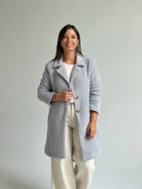 Tapado de paño color gris, con solapas clásicas, cierre frontal de dos botones y bolsillos laterales.
