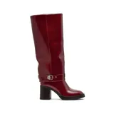 Bota de caña alta color bordó con acabado brillante, diseño de estilo ecuestre con correa decorativa en el tobillo y hebilla metálica. Cuenta con taco cuadrado y suela con plataforma.