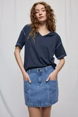 Falda corta de denim de corte recto con bolsillos delanteros aplicados, costuras pespunteadas a contratono y trabillas para cinturón.