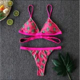 Bikini fucsia con estampado de cactus, compuesto por un corpiño triangular con tiras cruzadas debajo del busto y una bombacha tipo tanga cavada con ribetes fucsias.