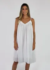 Solera midi color blanco con tirantes finos, escote en V con detalle de flecos y diseño amplio y fluido.