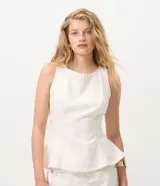 Blusa peplum sin mangas en sarga de algodón blanca, con escote redondo y diseño estructurado con volado amplio en el ruedo.