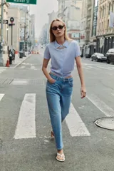 Chaqueta de punto celeste, de manga corta, con cuello solapa y cierre frontal con botones.