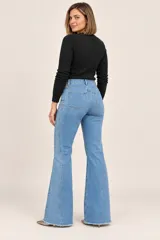 Jeans de denim azul con diseño flare, tiro alto, bolsillos delanteros y traseros, y terminaciones desflecarse en el bajo.