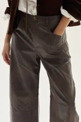 Pantalón de efecto cuero (PU) color gris oscuro/marrón, de tiro medio y calce barrel (pierna ancha y redondeada).