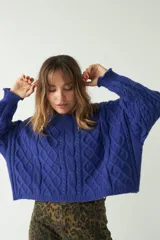 Sweater de punto color azul con diseño trenzado y textura en relieve, de fit amplio y cómodo, con hombros caídos y cuello redondo.