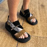 Sandalias de cuero vacuno negras con plataforma baja y tiras cruzadas en color negro, plateado y marrón.