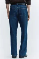 Jean de cinco bolsillos en denim de algodón rígido, con cintura clásica y cierre de botones. Modelo de corte relajado y piernas rectas.