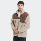 Campera de polar tipo sherpa en color beige, con paneles de contraste en color marrón en la parte superior y bolsillo frontal con cierre. Presenta cuello alto y cierre frontal completo.