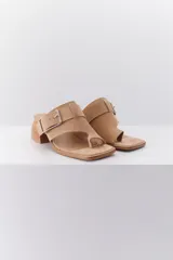 Sandalia color beige con tira ancha de cuero sobre el empeine, hebilla metálica plateada y taco geométrico de madera.