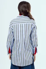 Camisa de manga larga con diseño a rayas verticales en tonos celestes y amarillos sobre fondo blanco, cuello camisero clásico y cierre frontal de botones.