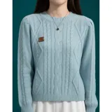 Buzo negro de punto con diseño trenzado y cuello redondo, de manga larga y ajuste cómodo con puños y dobladillo acanalados. Presenta una pequeña etiqueta metálica decorativa en el pecho.