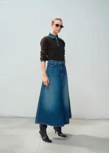 Falda midi de denim color azul, de corte evasé con tiro alto y diseño largo hasta las pantorrillas.