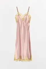 Vestido midi de satén en color rosado, con escote en pico y tirantes finos. Presenta detalles de encaje en color dorado a contraste en el escote y en el ruedo.
