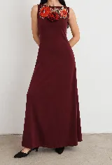 Vestido largo bordó sin mangas, de corte recto y escote redondo, con un aplique bordado de flores rojas en el pecho.