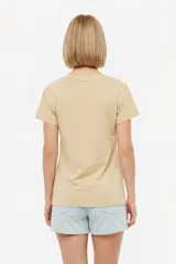Remera blanca de manga corta y cuello redondo, con diseño estampado en el frente que simula un sello postal con palmeras y la inscripción 'la paloma'.