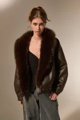 Campera de eco-cuero color marrón con cuello amplio de piel sintética al tono. Presenta un diseño de corte holgado, mangas largas y cierre frontal con botones.