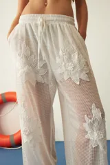 Pantalón blanco de red con bordado de flores y calce recto.