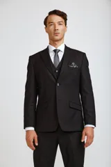 Traje de tres piezas compuesto por saco, chaleco y pantalón de vestir en color negro. El saco presenta solapas clásicas y cierre de botones, el chaleco cuenta con cierre frontal de botones y el pantalón es de corte recto y formal.