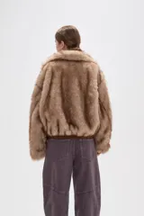 Campera de piel sintética en tono tostado, con cuello alto, cierre frontal y diseño holgado.