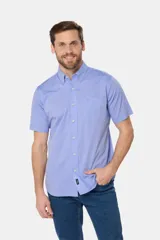 Camisa sport lisa de manga corta en color celeste, con cuello abotonado, cierre frontal con botones, bolsillo en el pecho y etiqueta decorativa en el ruedo.