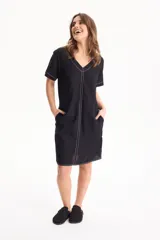 Vestido corto de lino color negro, con escote en V, manga corta y bolsillos laterales, destacado por costuras a contratono en color blanco.
