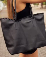 Bolso tipo tote de cuero negro, hecho a mano, con detalle de costura decorativa en el borde superior y asas largas para llevar al hombro.