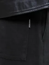 Pantalón negro de tiro alto y corte wide leg, con pliegues frontales y confeccionado en algodón.