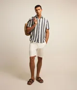 Bermuda básica masculina de sarga color blanco, con trabillas en la cintura, bolsillos laterales y cierre frontal con botón y cremallera.