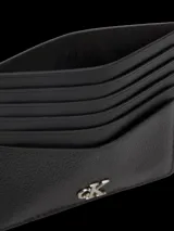 Tarjetero de cuero negro granulado con múltiples ranuras para tarjetas y el logo 'CK' metálico en la parte frontal.