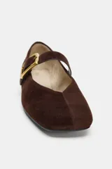 Bailarina plana de ante color marrón, con punta cuadrada y cierre mediante tira con hebilla metálica dorada en el empeine.