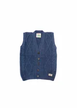 Chaleco azul de punto con diseño de trenzas y rombos, con cuello en V y cierre frontal con botones marrones.