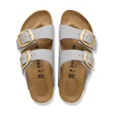 Sandalias Birkenstock modelo Arizona con dos tiras anchas ajustables en color gris piedra, hebillas grandes metálicas doradas, plantilla anatómica de corcho y suela de goma negra.