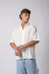 Camisa de manga corta confeccionada en lino, con cuello clásico y cierre frontal de botones. Presenta un corte relajado y textura liviana.