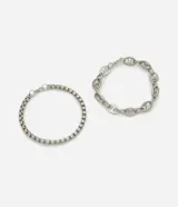 Kit de dos pulseras de metal con acabado plateado. Incluye una pulsera de eslabones ovales y una pulsera de eslabones cuadrados, ambas con diseño minimalista y moderno.