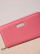 Billetera de poliuretano texturizado color rosado con cierre perimetral y logo metálico al frente.