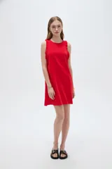 Vestido corto sin mangas en tono beige natural, con cuello redondo y volados delicados en las sisas.