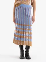 Pollera larga de tejido de punto con diseño de tablas, decorada con lentejuelas bordadas en un patrón de rayas verticales y bloques horizontales en tonos azul y tostado.