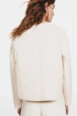 Chaqueta levemente acolchada de nylon guateado con escote redondo, cierre frontal con botones a presión y bolsillos laterales insertados.