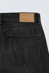 Jeans regular fit de denim de algodón en color gris con efecto lavado, tiro medio, diseño de cinco bolsillos y cierre frontal con botones.