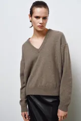 Jersey de punto liso confeccionado en mezcla de cashmere y lana, con cuello en pico y manga larga de diseño holgado.