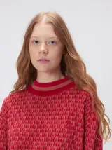 Sweater de tejido de punto jacquard con diseño geométrico, cuello redondo y puños acanalados en contraste de color verde y beige.