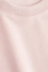 Buzo de tejido de punto color rosa pálido, con cuello redondo, hombros caídos y puños y bajo acanalados.