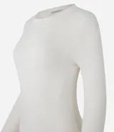 Suéter ajustado de punto color crema, con cuello redondo y mangas largas con botones metálicos en los puños. Confeccionado con viscosa sostenible.