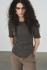 Camiseta de algodón color terracota con efecto lavado, cuello redondo y manga corta. Posee un bajo redondeado.