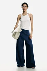 Pantalón sastrero de tiro alto y perneras amplias en color azul, con pinzas delanteras y traseras marcadas, y trabillas para cinturón.