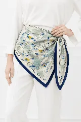 Pañuelo cuadrado de seda con estampado floral de flores de loto en tonos azules, blancos y amarillos, con borde azul marino y marco decorativo.